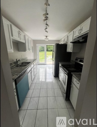 A kitchen with white cabinets and black appliances.