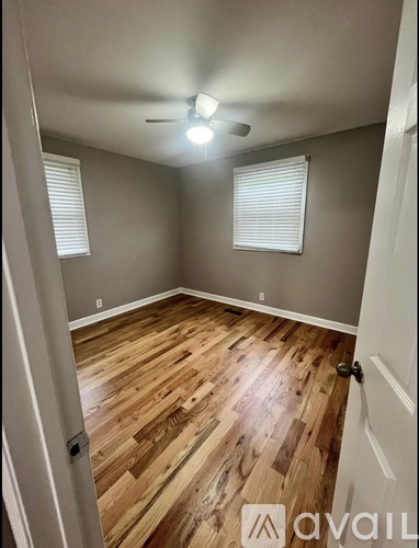 A room with wooden flooring and a ceiling fan.
