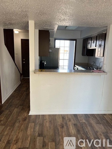 A kitchen area with wooden floors and white walls.