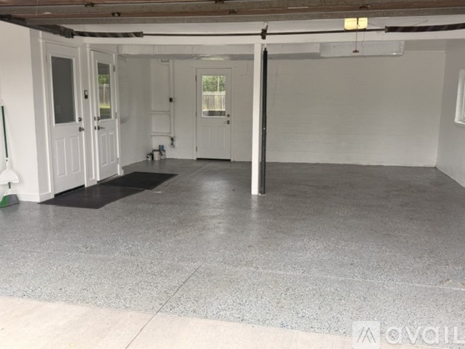A spacious room with a grey floor and white walls.