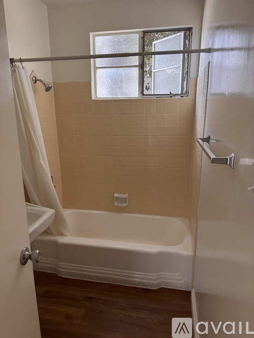 A bathroom with a white tub and a window.