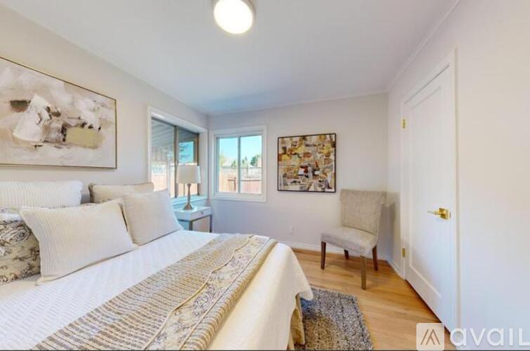 A bedroom with a large bed and a painting on the wall.