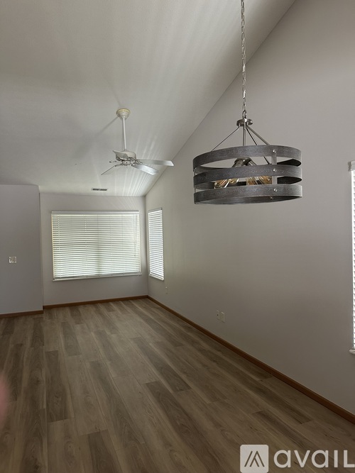 A room with wooden floors and a hanging light fixture.
