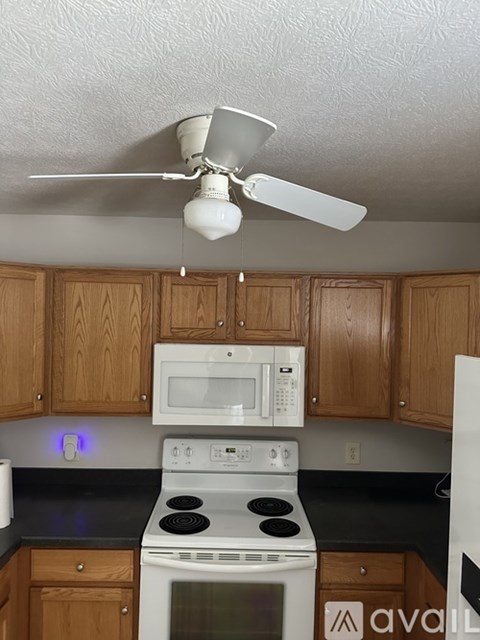 A kitchen with a white stove and microwave above it.