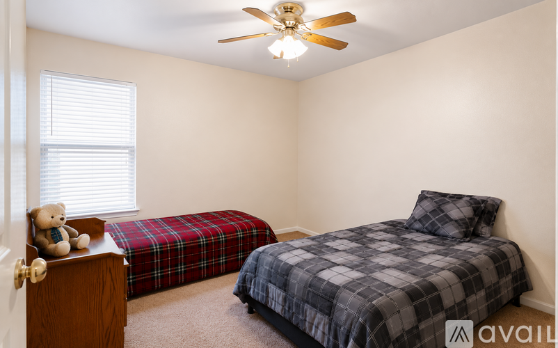 A bedroom with a bed and a teddy bear on the nightstand.