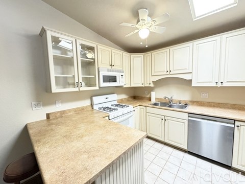 A kitchen with white cabinets and a beige countertop.