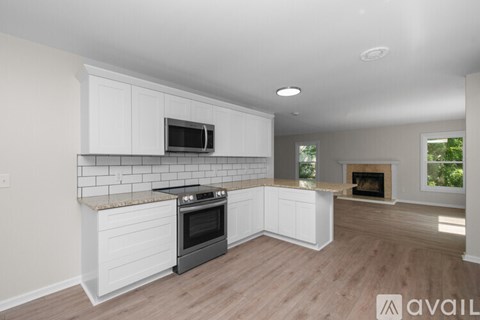 A kitchen with white cabinets and a black oven.