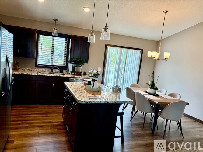 A kitchen with dark wood cabinets and a granite countertop.
