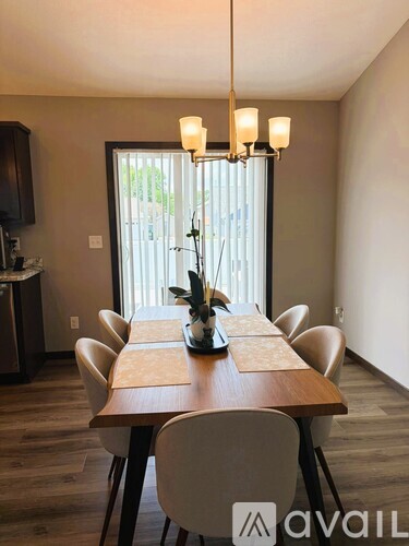 A dining room with a wooden table and chairs.