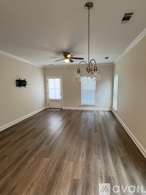 A room with wooden flooring and a ceiling fan.