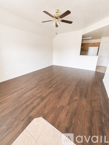 A room with wooden flooring and a ceiling fan.
