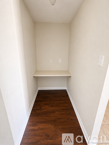 A long hallway with wood floors and white walls.