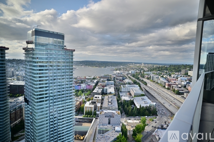 A view from a high-rise building looking out over a cityscape with a cloudy sky.
