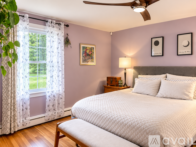 A bedroom with a large bed and a ceiling fan.