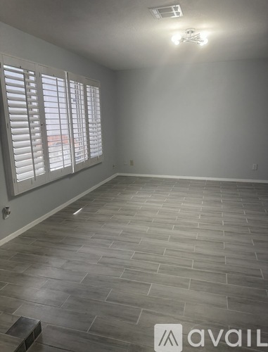 A room with a tiled floor and a window with blinds.