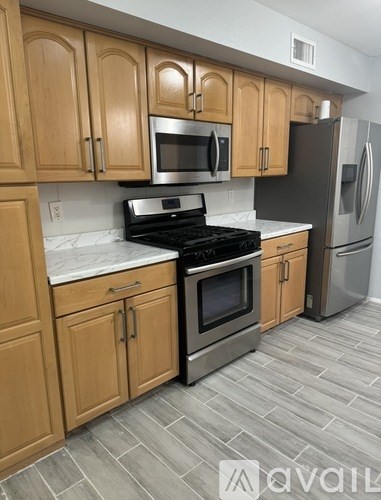 A kitchen with wooden cabinets and a black stove top oven.