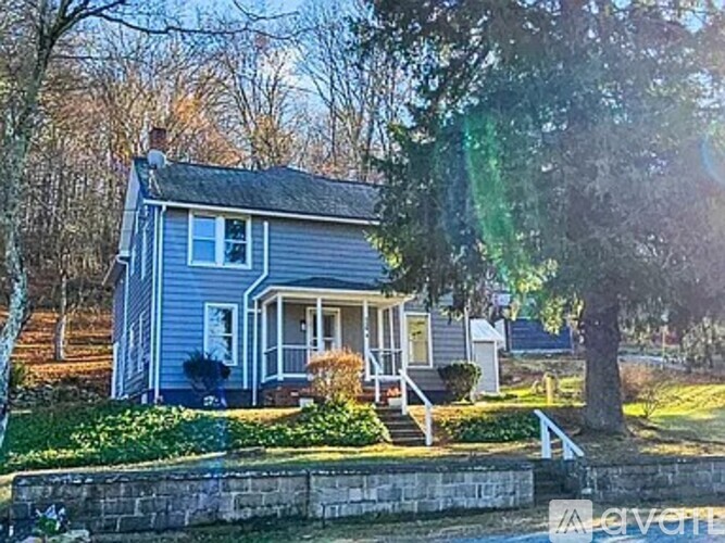 A house with a blue exterior and a white porch.