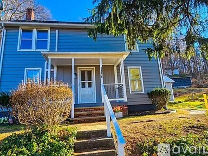 A blue house with a white door and a small porch.