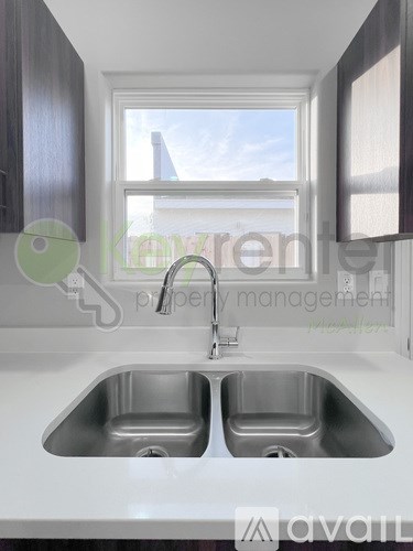 A modern kitchen with a double sink and a window.