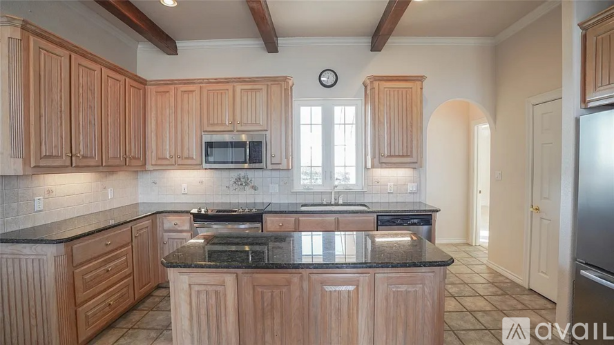 A kitchen with wooden cabinets and a black countertop.