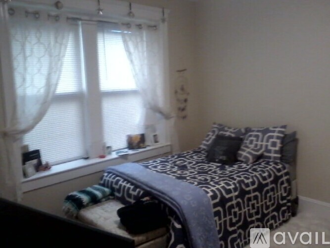 A bedroom with a bed and a window with curtains.