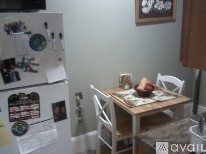 A kitchen with a fridge covered in magnets and a table with chairs.