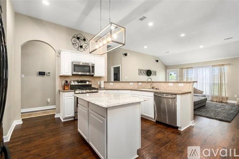 A modern kitchen with white cabinets and a large island.