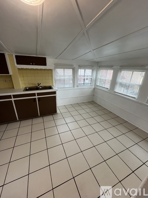 A kitchen with white tiled floors and a brown counter.