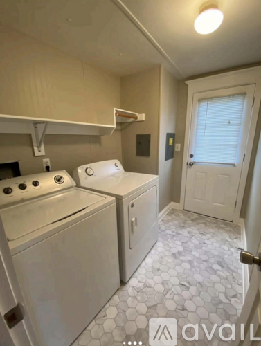 A small laundry room with a washer and dryer.