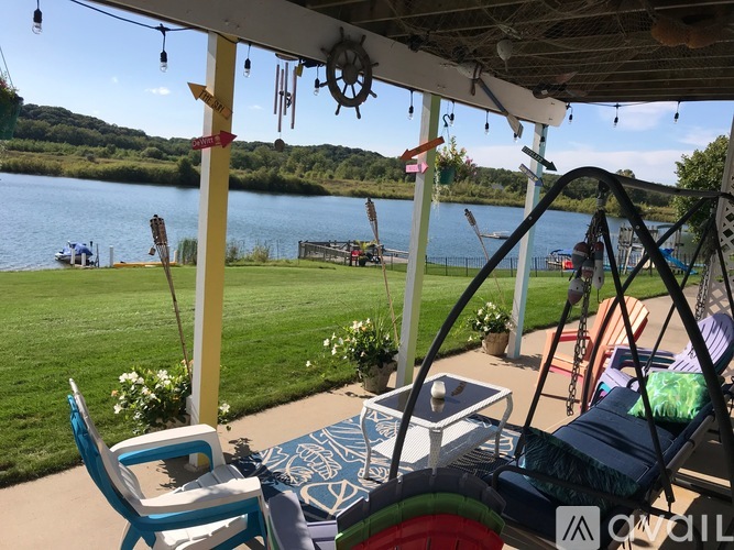 A patio with a table and chairs overlooking a lake.