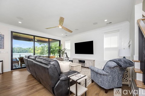 A living room with a grey couch and a black television.