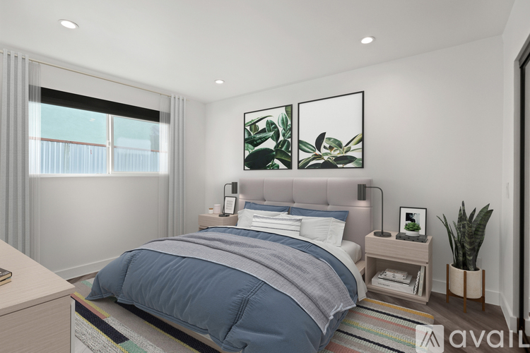 A bedroom with a large bed and a plant on the side table.