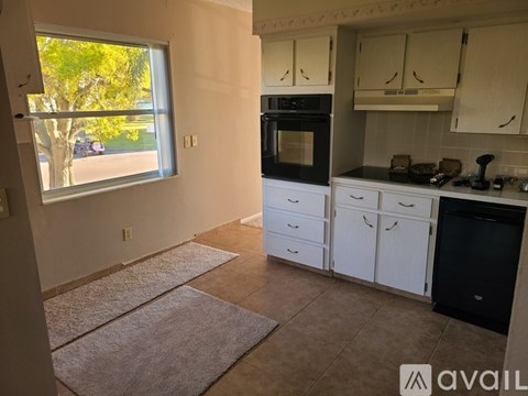 A kitchen with white cabinets and a black oven.