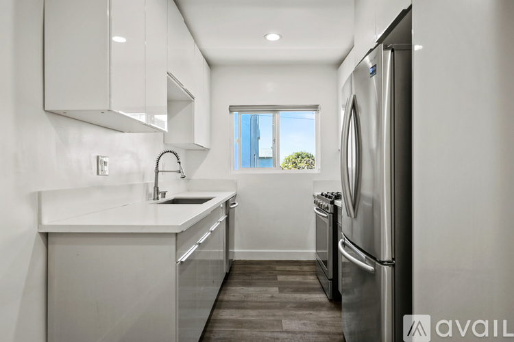A modern kitchen with a refrigerator, sink, and stove.