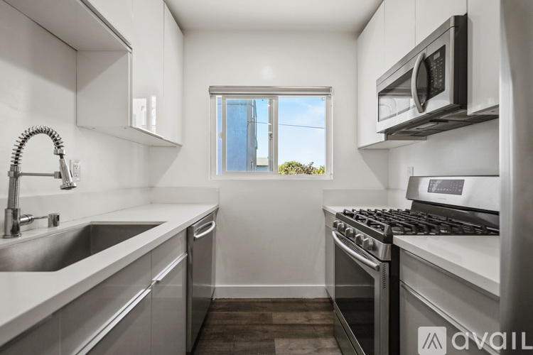 A modern kitchen with stainless steel appliances and a window.