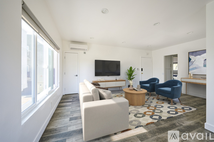 A spacious living room with a large couch, a television, and a coffee table.