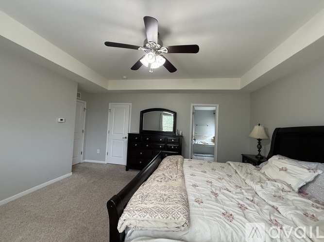 A bedroom with a large bed and a ceiling fan.