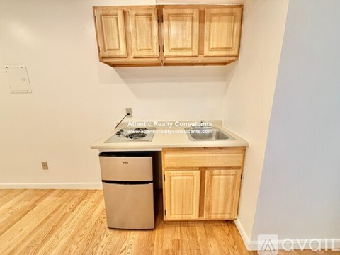 A kitchen with wooden cabinets and a stainless steel dishwasher.