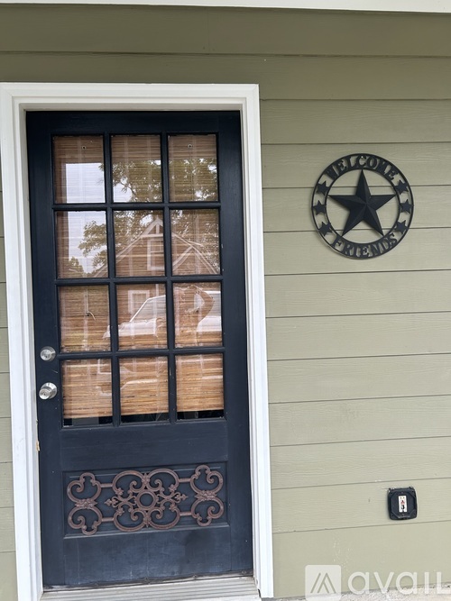 A black door with a window and a star on the wall.