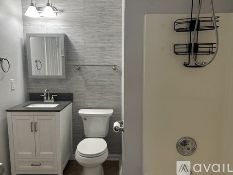 A bathroom with a toilet, sink, and shower.