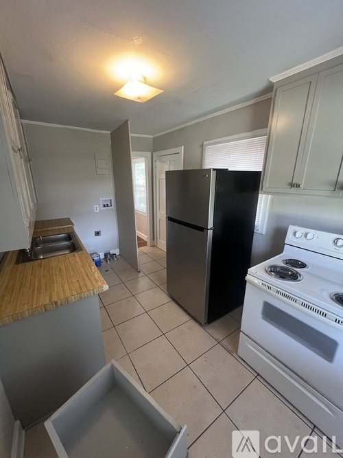 A kitchen with a white stove and a black fridge.