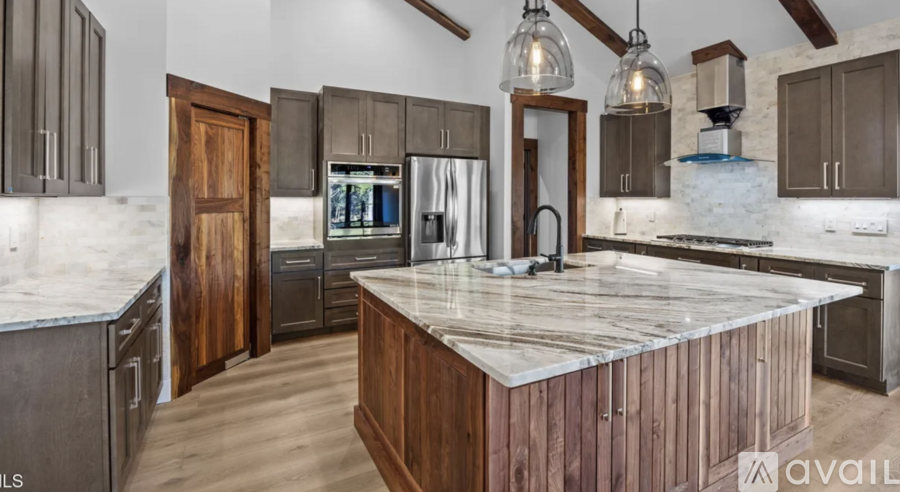 A kitchen with a marble countertop and wooden cabinets is available for purchase.