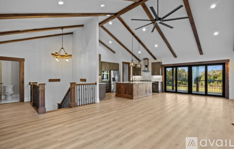 A spacious living room with wooden floors and a large window.