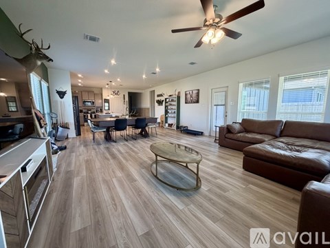 A living room with a brown couch and a wooden floor.
