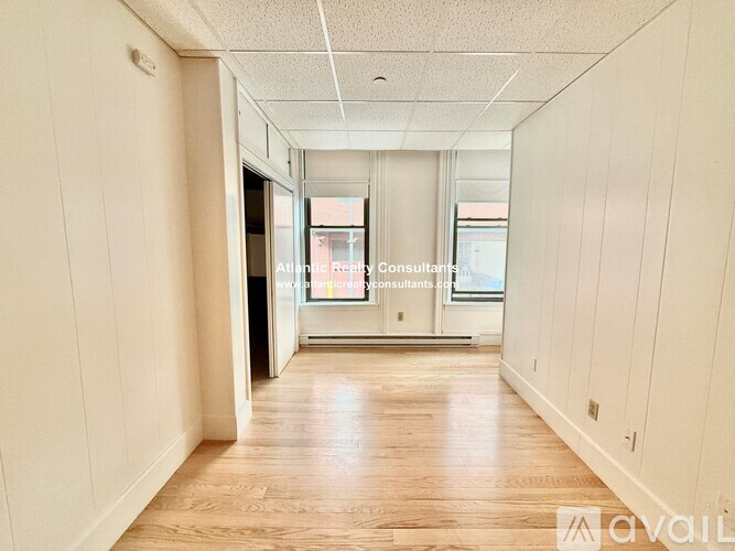 A long hallway with a sign that says "Available".