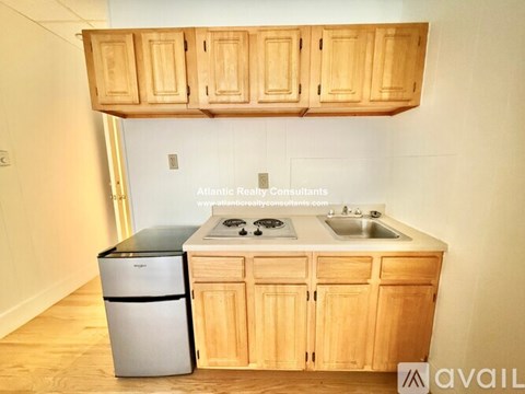 A kitchen with wooden cabinets and a stainless steel dishwasher.
