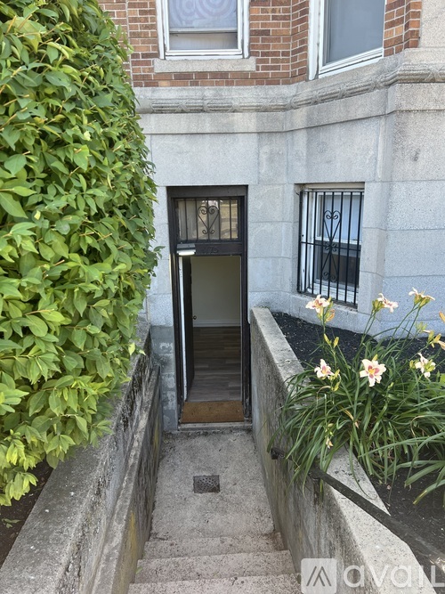 A building with a black door and a window with bars.