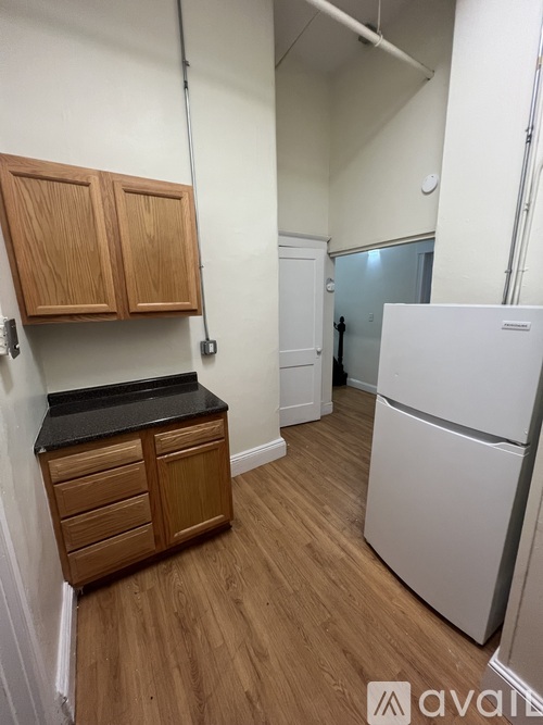 A kitchen with wooden cabinets and a white fridge.