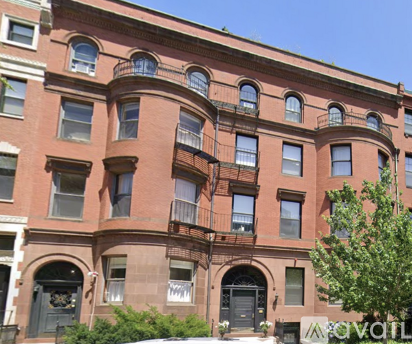 A red brick building with a balcony on the second floor.