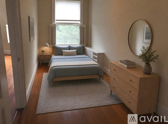 A bedroom with a bed, nightstand, and a round mirror on the wall.
